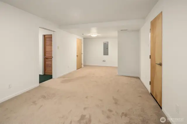 Here’s another view of the downstairs flex room, showcasing its generous size and multiple access points to adjacent spaces including a massive under-stair closet, mechanical room, and fourth bedroom or office. The open layout and neutral finishes make it easy to adapt for a variety of uses: a media lounge, playroom, guest quarters, or ??? With its quiet location on the lower level and direct outdoor access, this room is full of potential.