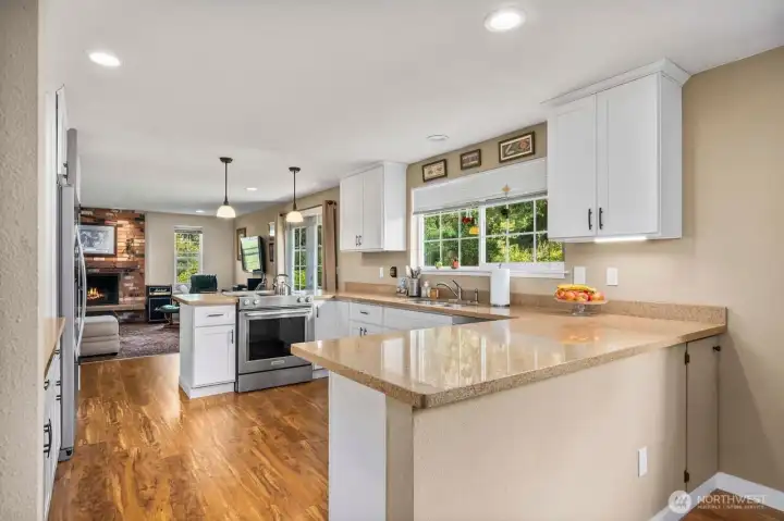 Updated kitchen with newer quartz counter tops, cabinets, under mount  sink and appliances that stay.