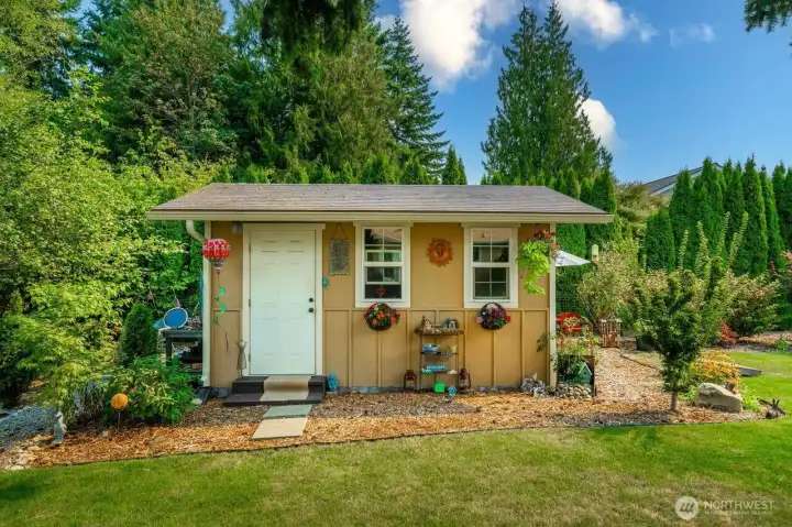 Darling shed with a whimsical little walking path behind.  Every where you turn your head there is something to see in this yard!