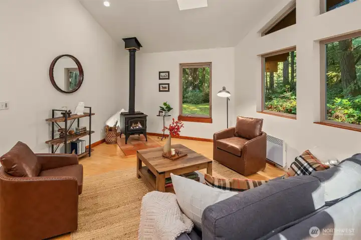 Wood stove is a wonder; owner heated almost exclusively with this. Ceiling fan helps move warm air into the room. Views into the serene setting from every room -- oh so private!