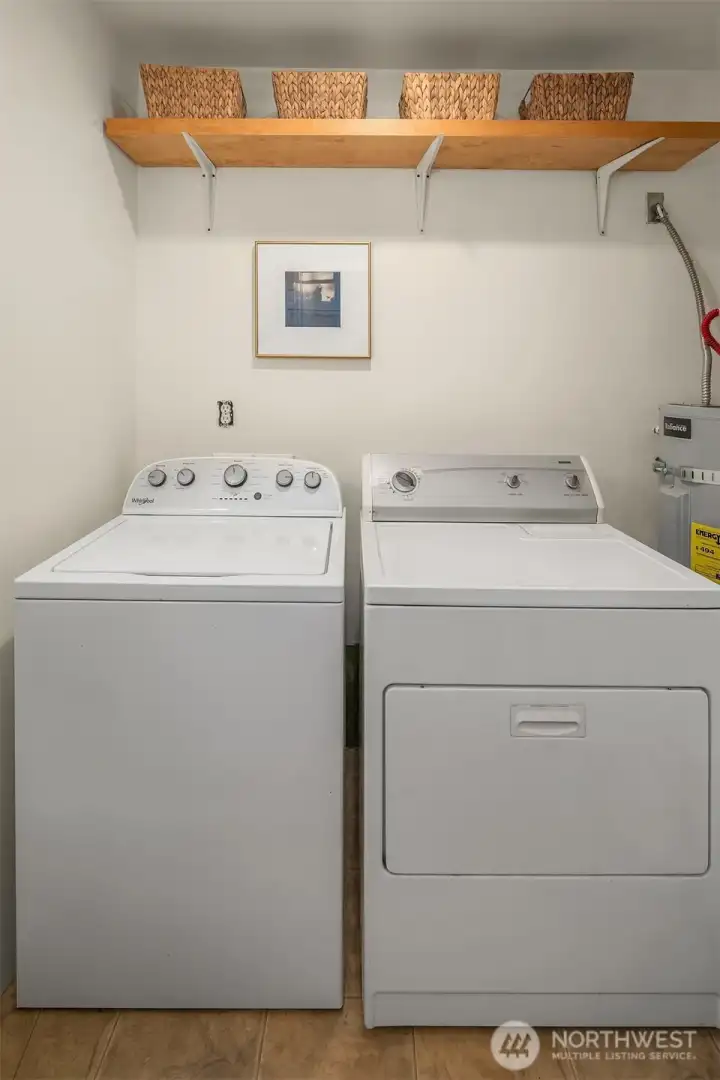 Washer/Dryer in the bath with handy storage shelf.