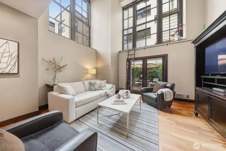 Soaring 20' ceilings and oversized windows fill the living room with natural light.