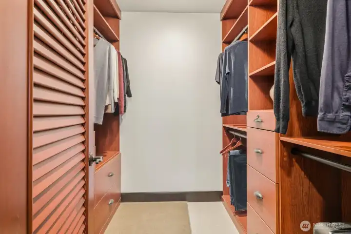Walk-in closet featuring custom-built woodwork for your garments.