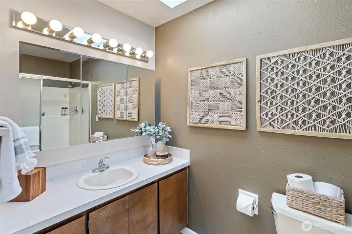 A skylight in the en suite bathroom offers a unique balance of daylight and discretion, allowing light to pour in from above without compromising privacy in the room. A large walk-in shower and wide vanity ease the daily routines and accommodates improved accessibility.