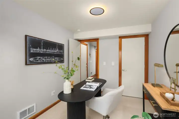 Main level bedroom offers versatility with access via a slider to the fenced-in backyard.