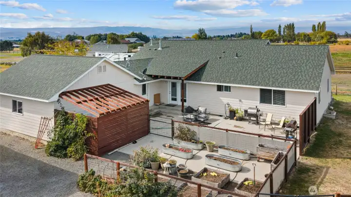 Large patio and covered hot tub area next to the raised garden bed!