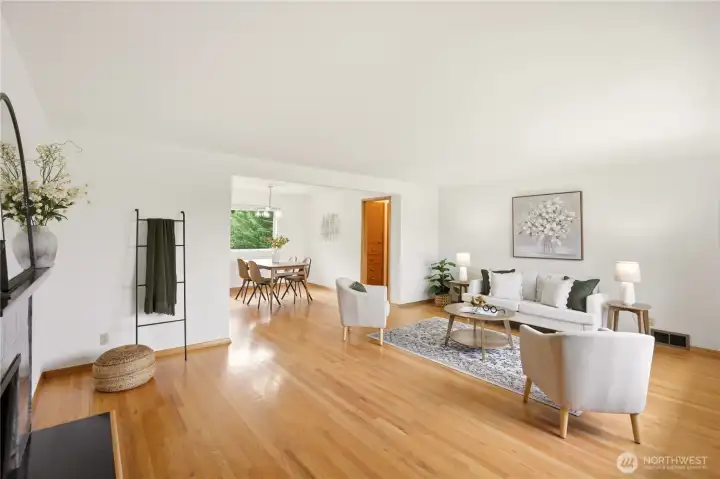 Open concept living room & dining room with lovely original hardwood floors, wood burning fireplace, original mid-century doors and trim and a fresh paint job!