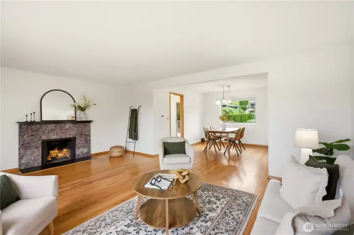 Another look at the open living room & dining room. Lovely granite fireplace mantle and surround.