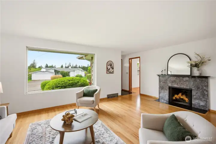 A look at the west facing picture window and fireplace. There's also a coat closet just inside the entry door and a den/bedroom near the entry door.