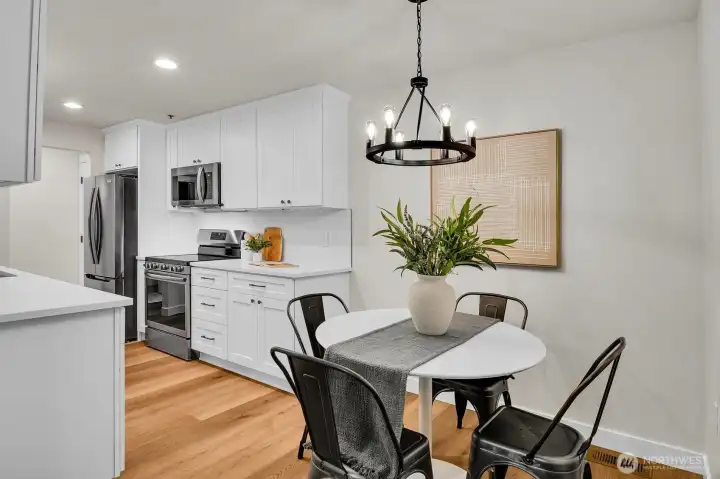 Fully remodeled kitchen with shaker cabinets, quartz counters, subway tile backsplash and stainless appliances, open to dining area.