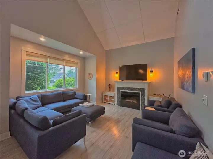 Inside, soaring cathedral ceilings of the great room with fireplace and oversized windows create a bright yet cozy atmosphere. Inside, soaring cathedral ceilings of the great room with fireplace and oversized windows create a bright yet cozy atmosphere.