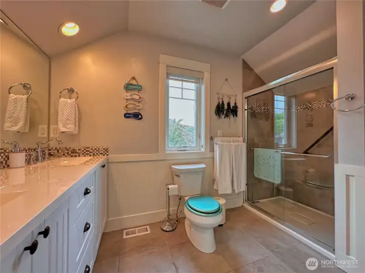 Upper-level guest bedrooms are joined by a thoughtfully designed Jack-and-Jill bathroom with a spacious walk-in shower. Upper-level guest bedrooms are joined by a thoughtfully designed Jack-and-Jill bathroom with a spacious walk-in shower.