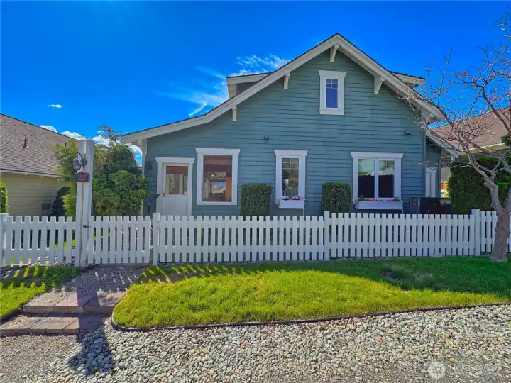 A quintessential white picket fence creates an inviting cottage-style setting. A quintessential white picket fence creates an inviting cottage-style setting.