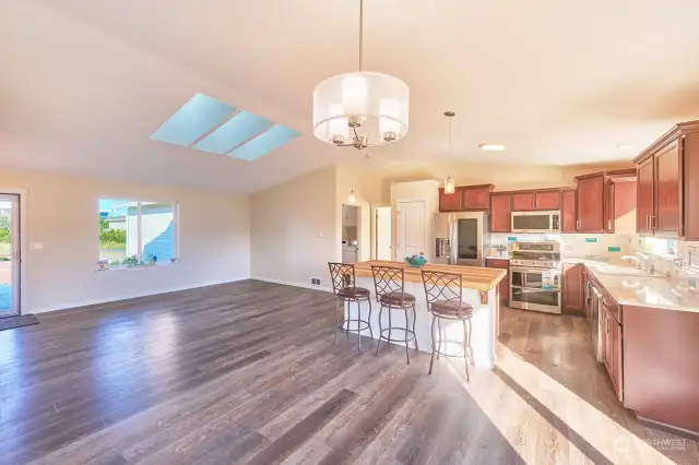 Pretty kitchen has quartz counters, tiled backsplash and stainless appliances