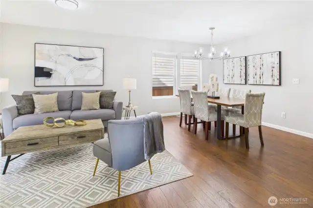 This beautifully staged open-concept living and dining space offers the perfect blend of function and style. Rich hardwood floors, large windows, and designer lighting set the tone for everyday comfort and effortless entertaining.