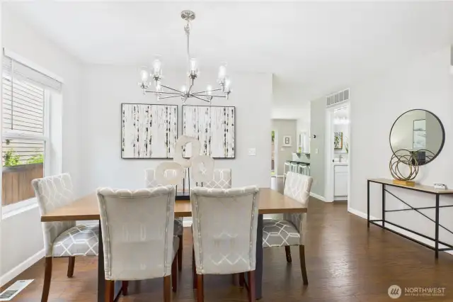 Welcome guests into this bright and airy formal dining room, featuring fresh paint and a modern chandelier that adds a touch of sophistication. The space flows seamlessly into the main living areas, perfect for entertaining or intimate family dinners.