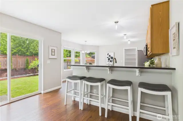 This charming breakfast bar is the perfect spot for casual meals or morning coffee, with stylish bar seating and serene views of the lush, fully fenced backyard. The sliding glass door offers seamless indoor-outdoor living.