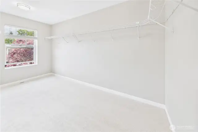 Step into this massive walk-in closet—a dream space with wraparound wire shelving and plush new carpeting. Whether you're a fashion lover or just want organized storage, this closet delivers abundant room and natural light.