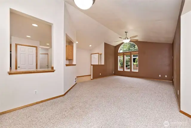 Vaulted ceilings and arch windows in living room let a lot of natural light in and make the home live large.