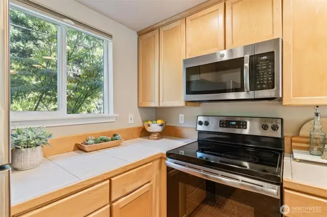 Modern kitchen with sleek countertops, ample cabinetry, and stainless steel appliances, designed for effortless cooking.