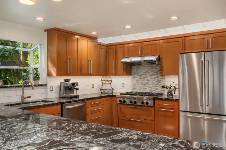 The garden window and skylights flood the kitchen with natural light. Notice the cherry cabinets.