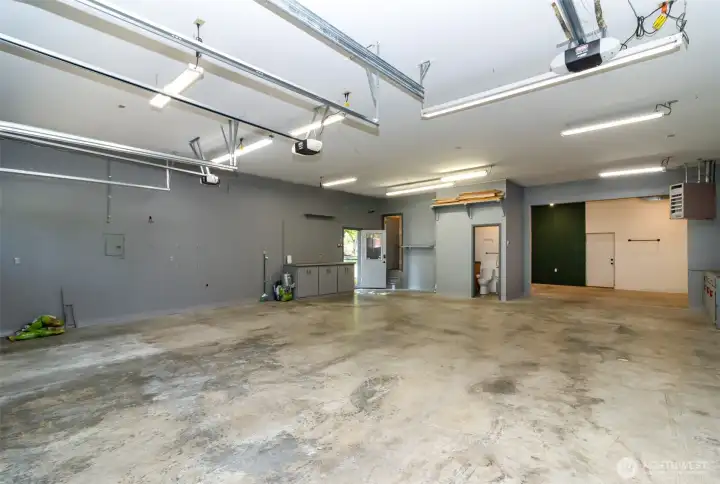 Behind the entry door are stairs to the generous storage loft.  Also shown is the door to the half bathroom.  The shop also features a Reznor heater and it's piped for compressed air.