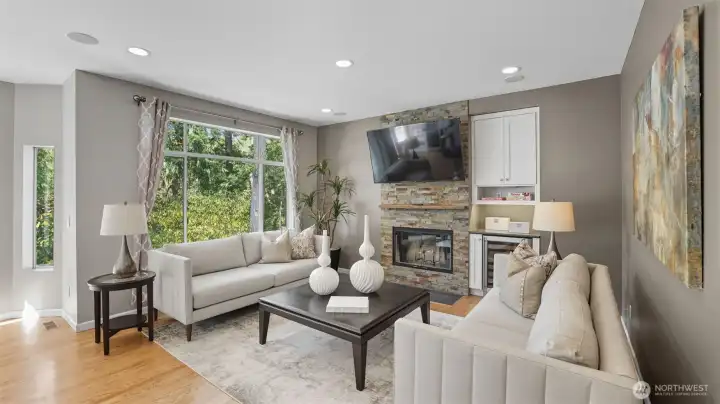 The large family room window allows light to stream in along with the private green belt views.  The mounted large screen TV remains with the home.