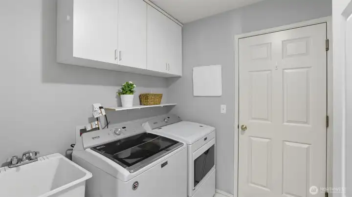 The utility room has a deep sink, cabinets and the Maytag washer and dryer remain with the home.