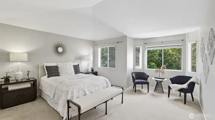 The primary suite is spacious with a sitting area, French doors and special peaked ceiling.  The suite looks directly into the lush private greenbelt.