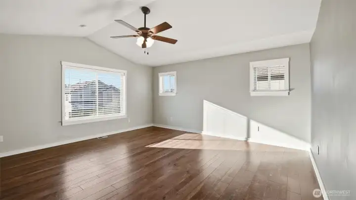 Bright and spacious primary bedroom features double-door entry, vaulted ceilings with fan and more.