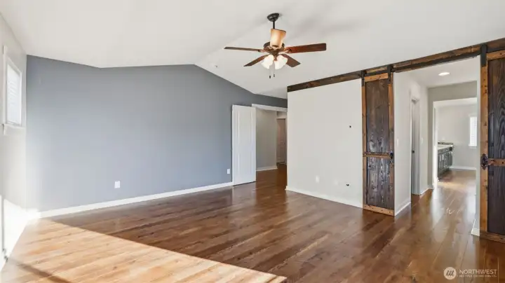 Primary bedroom with stylish barn sliding doors leading to spa like 5-piece bath.