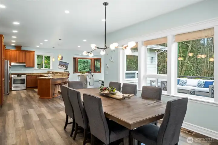 Generous formal dining space with large windows overlooking the deck and wooded greenbelt, perfect for gatherings and holiday dinners.