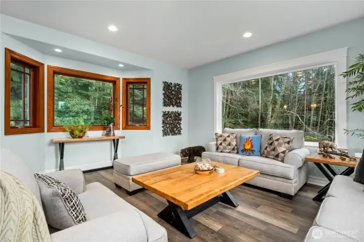 Flexible den or sitting area filled with natural light and serene forest views—ideal for reading, relaxing, or a home office.