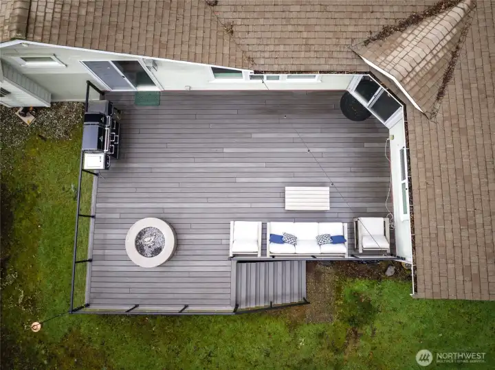 Aerial perspective showcases the spacious entertaining deck, ideal for gatherings, outdoor dining, and relaxing in the privacy of your wooded surroundings.