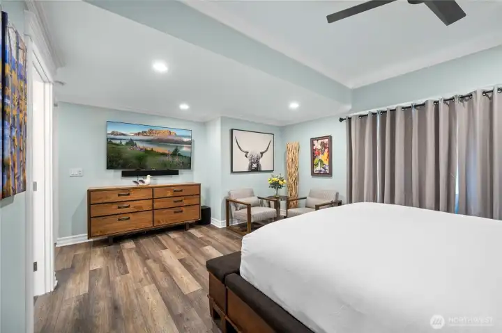 Spacious primary bedroom with crown molding, ceiling fan, and peaceful views creating a comfortable retreat.