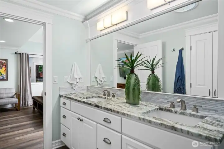 Elegant primary bathroom with dual vanities, granite countertops, and abundant storage.