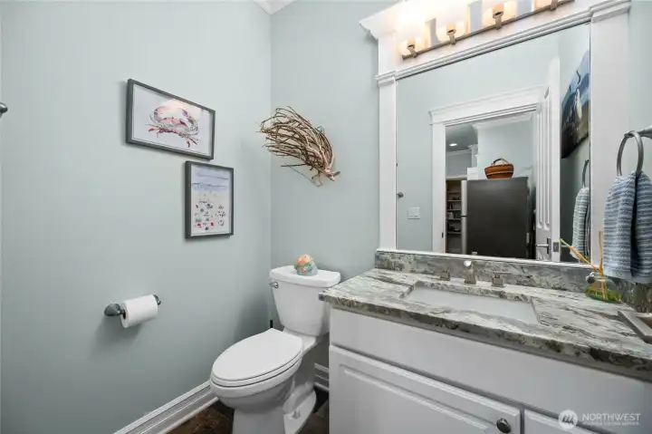 Stylish main-level powder room with granite vanity, modern fixtures, and elegant trim details.