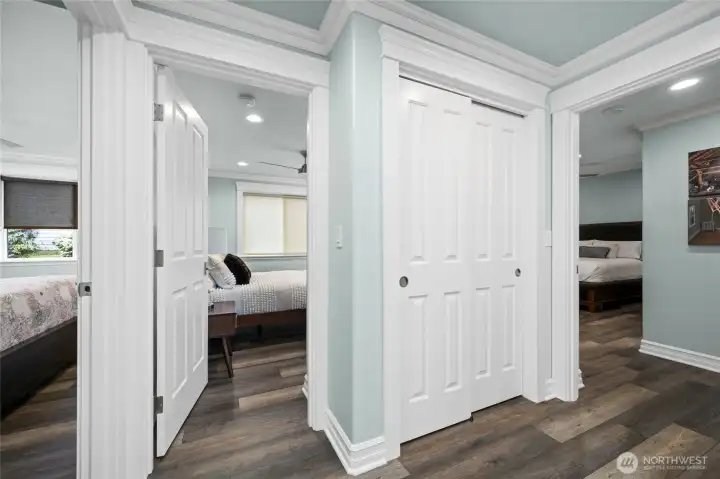 Wide hallway with beautiful millwork and durable flooring leads to the private bedroom wing of the home.
