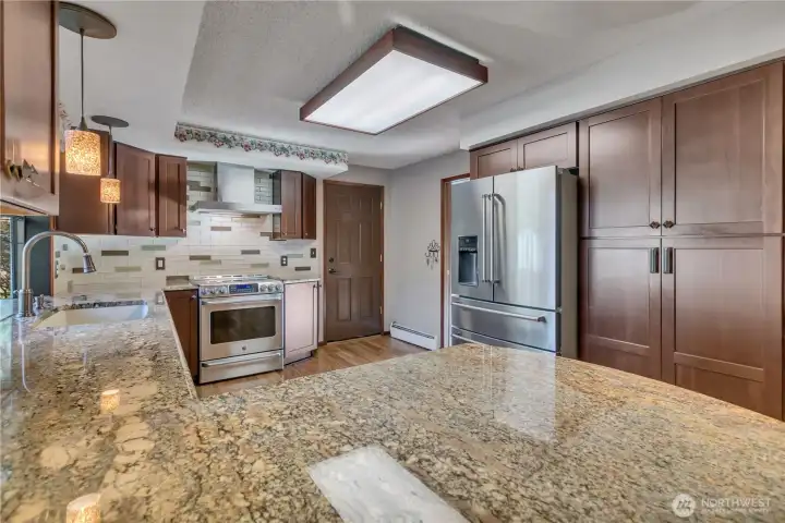 Expansive counters provide ample space for meal preparation, casual dining, and hosting gatherings.