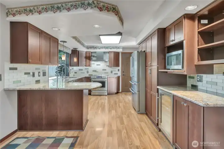 Open kitchen layout flows seamlessly into nearby living spaces, making entertaining effortless. Notice the wine refrigerator on the right!