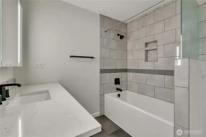 Here is the other view of the stylish main bath with tile surround and clean modern design.