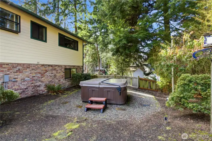 Off to the side is a hot tub where you can relax and enjoy the beautiful landscaping.
