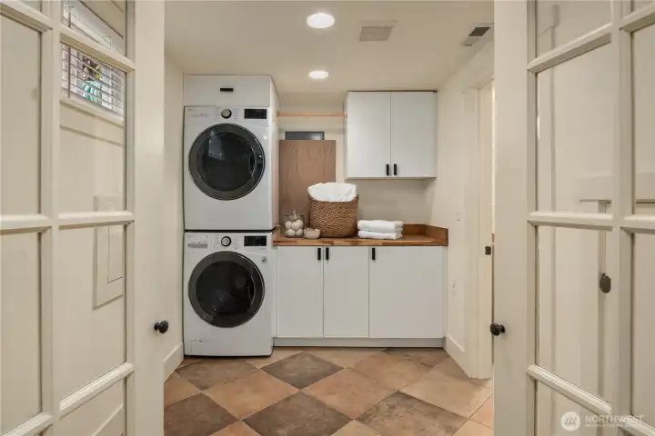 This enormous laundry room has full size stack washer and dryer and lots of storage. The second bath is off to the right.