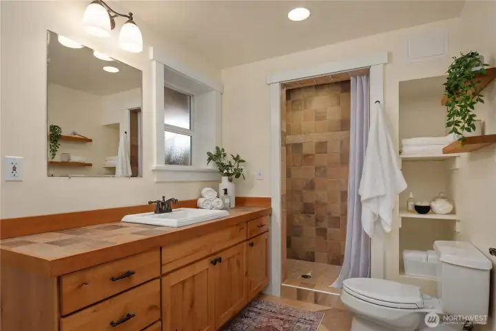 This luxurious bathroom features extensive tile work and an oversized vanity just off the oversized shower.