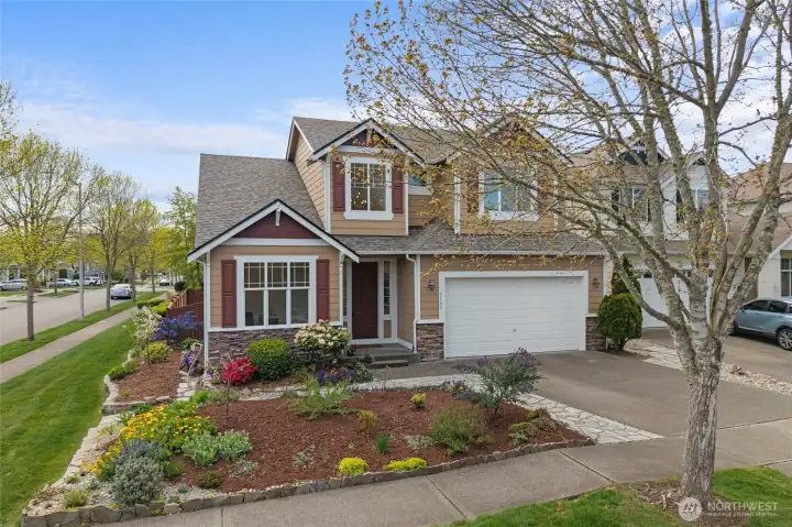 CORNER LOT | This lovely 2,221 sf home sits on a spacious corner lot with beautiful flowers and trees just starting to come into bloom.