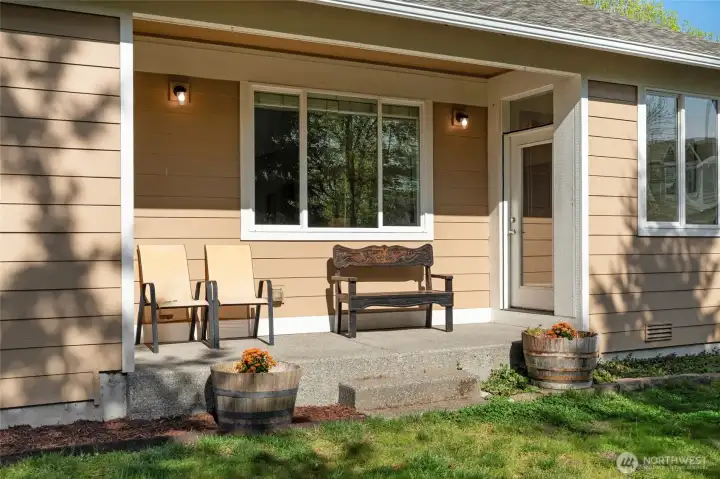 THE BACK PORCH | You'll enjoy relaxing on the back porch with a door to the eat in kitchen on the right of the photo and a door to the main floor primary bedroom on the left.