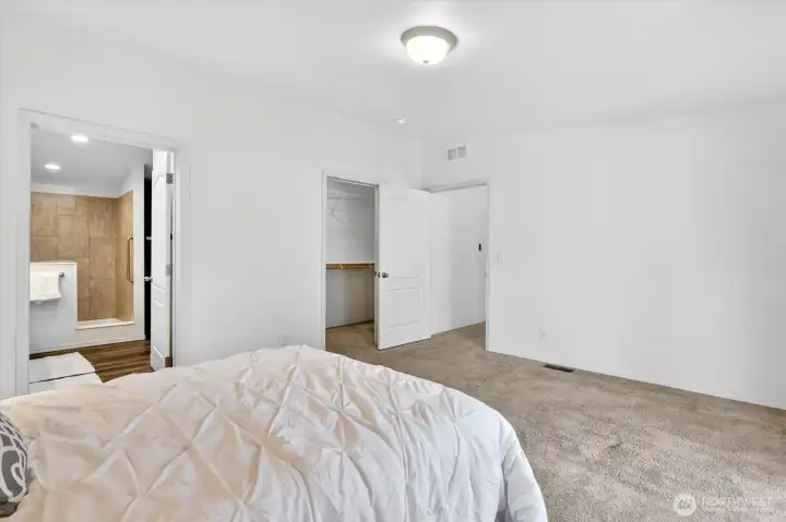 Primary bedroom with attached bathroom and walk-in closet