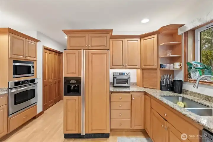 Warm wood cabinetry and quality finishes enhance this inviting kitchen space.