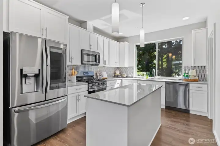 The heart of the home — a chef-inspired kitchen featuring quartz counters, shaker cabinetry, gas cooking, and center island. The heart of the home — a chef-inspired kitchen featuring quartz counters, shaker cabinetry, gas cooking, and center island.