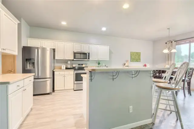 Spacious kitchen with stainless steel appliances, island with eating bar & kitchen sink overlooking the living area